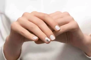 Elegant white nail ideas with a unique design on the ring finger.